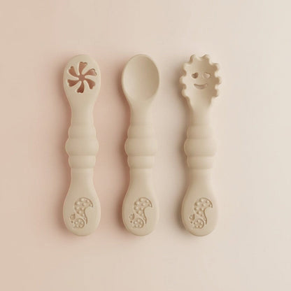 DearXime 3-piece beige silicone baby utensil set with ergonomic handles, including a slotted spoon, spoon, and fork.